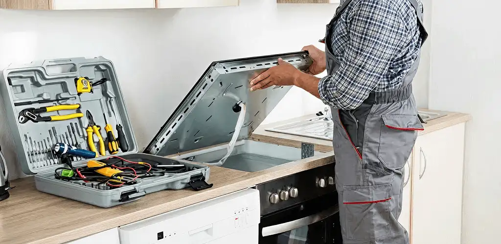Handyman repairing a cooktop and checking wiring connections in Raleigh, NC
