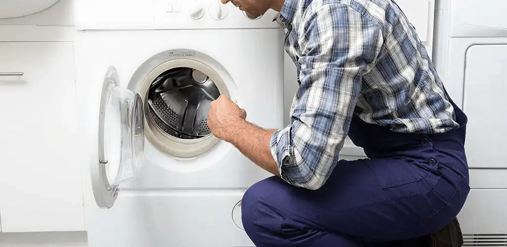 Handyman inspecting a dryer drum and internal parts for repair in Raleigh, NC