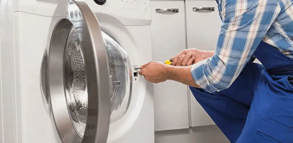 Handyman repairing a clothes dryer and checking electrical connections in Raleigh, NC