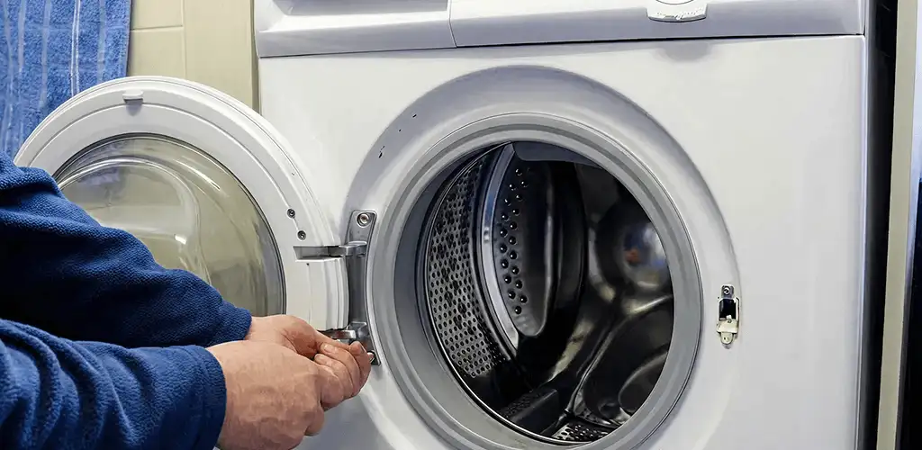Washing machine repair handyman checking a front-load washer door and latch in Raleigh, NC