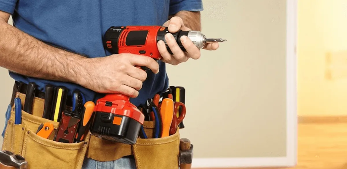 Handyman holding a power drill for home repairs and installations in Raleigh, NC