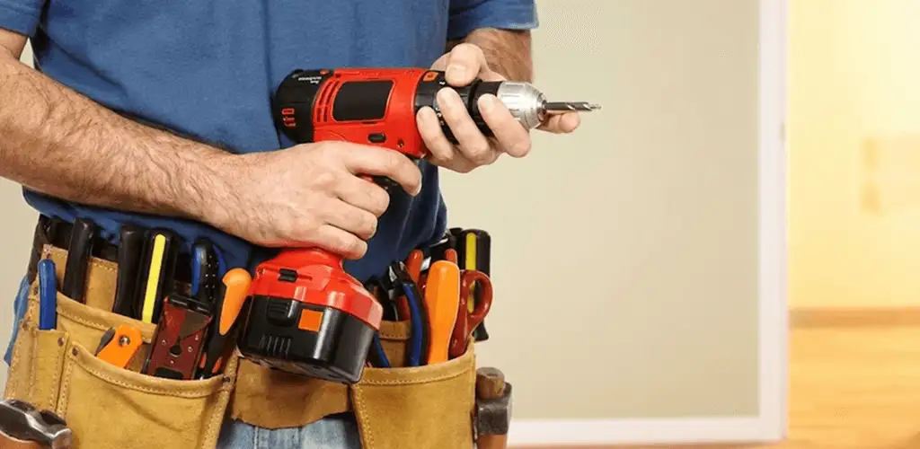 Handyman holding a power drill for home repairs and installations in Raleigh, NC