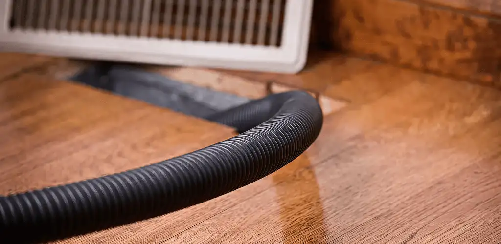 Air duct cleaning hose inserted into a floor vent for ductwork cleaning in Raleigh, NC