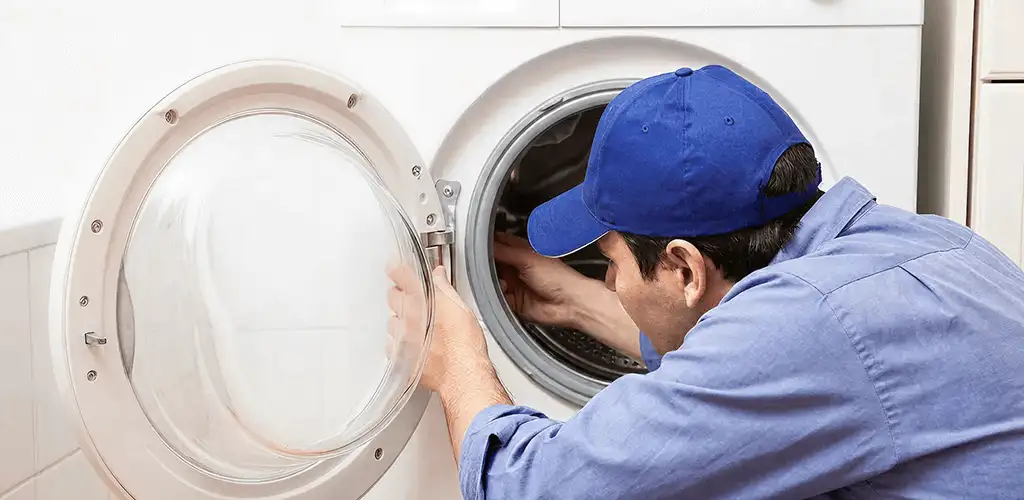 Washing machine repair handyman inspecting a front-load washer drum in Raleigh, NC